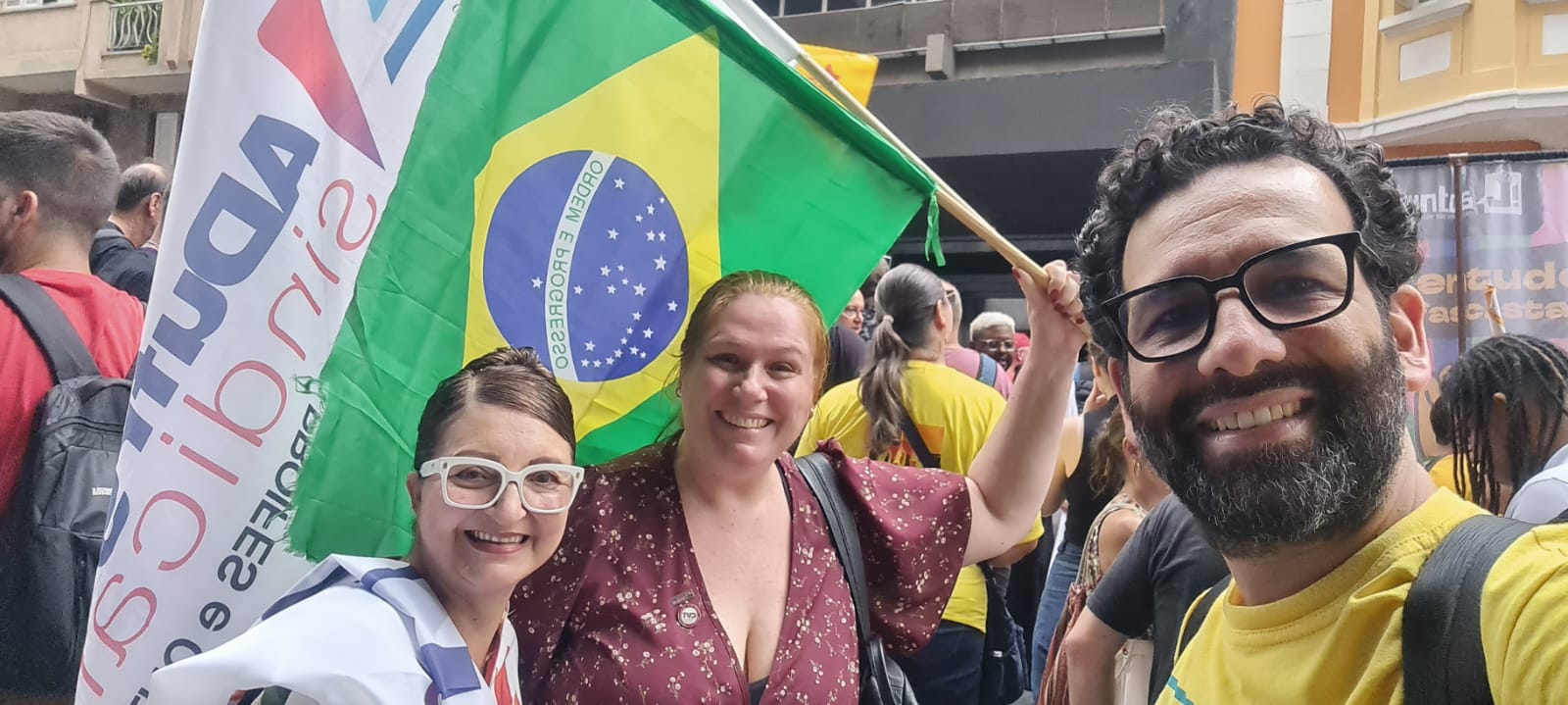 Presidenta do Conselho de Representantes, Sônia Mara Ogiba; vice-presidentedaADUFRGS, Ana Boff de Godoy, e diretor de EBTT, Roger Elias, com bandeiras do Sindicato e do Brasil